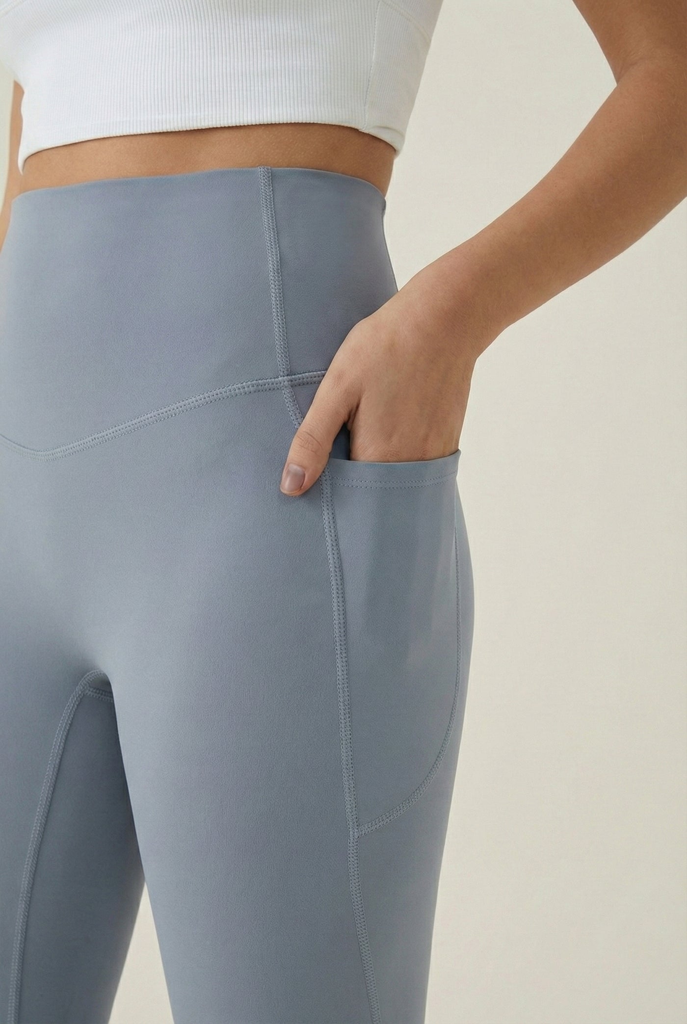 Women's high-waisted Contour Pocket Legging in Chambray blue, featuring a seamless front, hidden side pockets, and body-contouring compression fit.