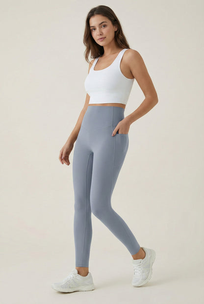 Women's high-waisted Contour Pocket Legging in Chambray blue, featuring a seamless front, hidden side pockets, and body-contouring compression fit.