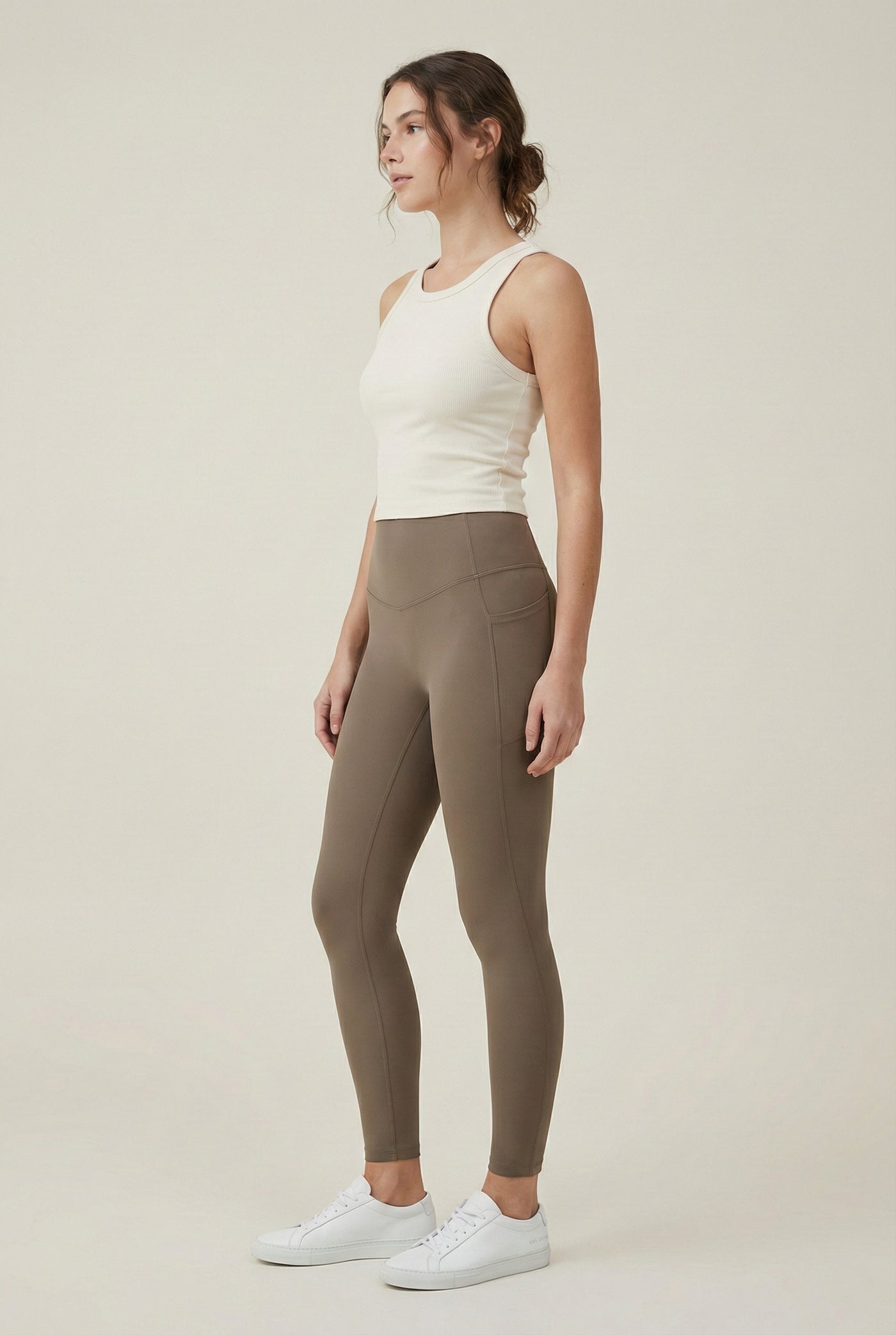 Women's high-waisted Contour Pocket Legging in Portabella brown, featuring a seamless front, hidden side pockets, and body-contouring compression fit.