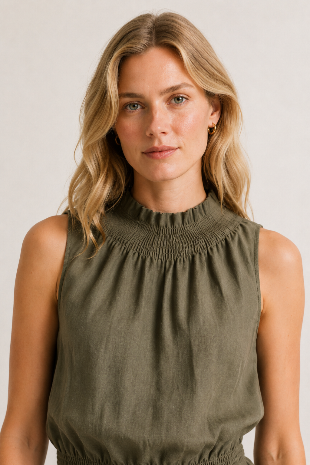 Woman wearing a premium minimalist cypress green two piece set with sleeveless top and wide leg pants