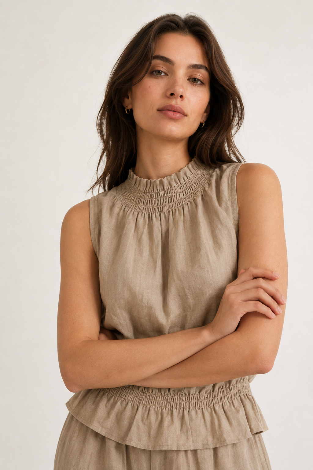 Woman wearing a premium minimalist dune beige two piece set with sleeveless top and wide leg pants