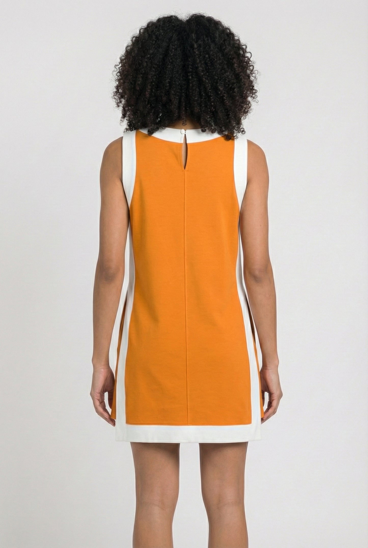 Model wearing the Lohnr Game Day Set in Bright Orange, a 100% cotton two-piece outfit featuring hidden shorts with pockets.