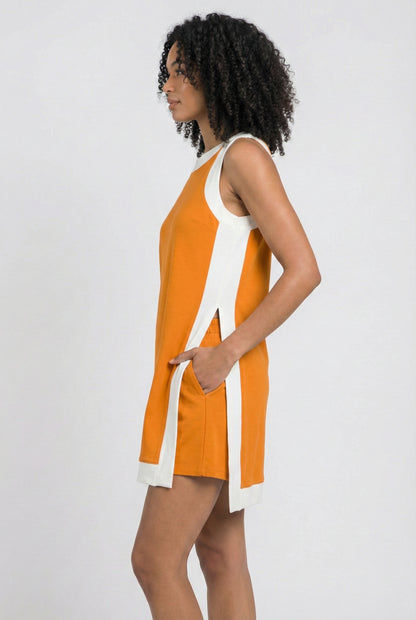 Model wearing the Lohnr Game Day Set in Bright Orange, a 100% cotton two-piece outfit featuring hidden shorts with pockets.