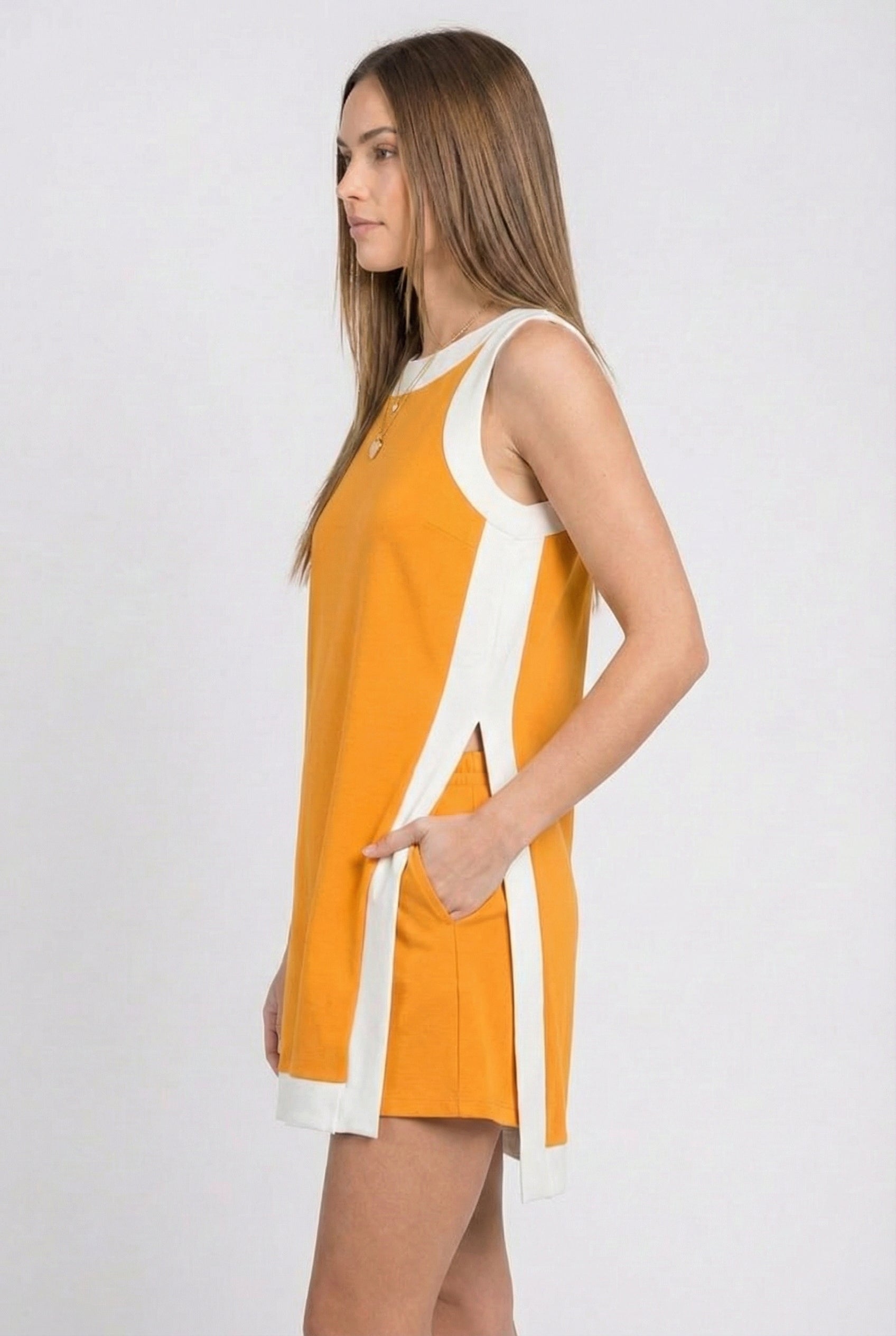 Model wearing the Lohnr Game Day Set in Orange, a 100% cotton two-piece outfit featuring hidden shorts with pockets.