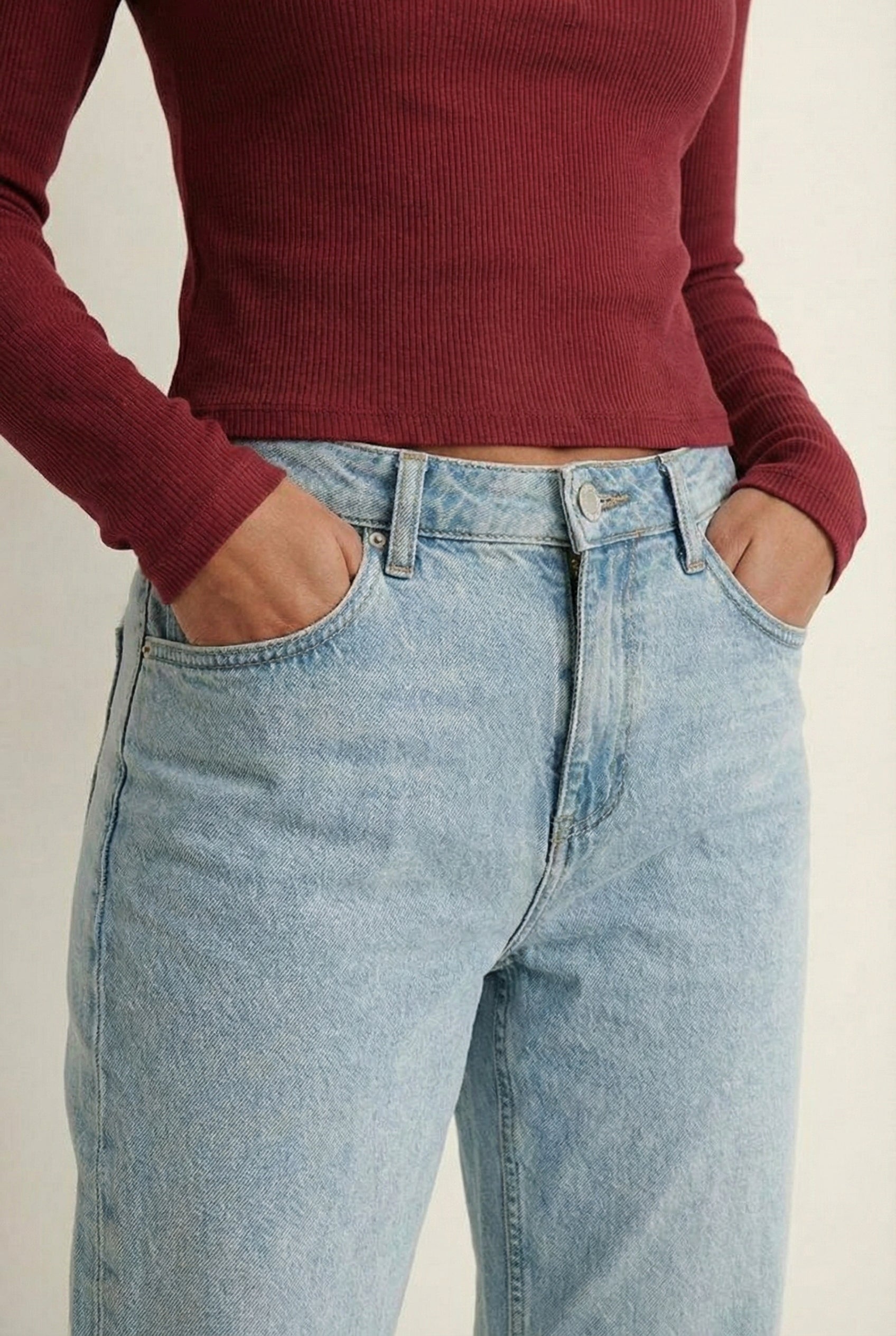 Woman wearing the LOHNR Haven Henley in Cabernet, a deep burgundy ribbed long-sleeve top with a button placket, styled for effortless everyday luxury.