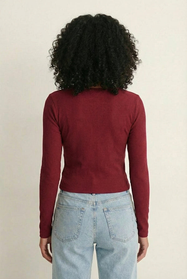 Woman wearing the LOHNR Haven Henley in Cabernet, a deep burgundy ribbed long-sleeve top with a button placket, styled for effortless everyday luxury.