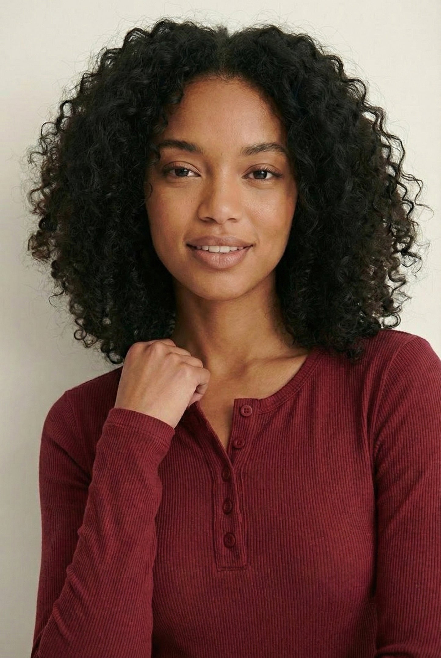 Woman wearing the LOHNR Haven Henley in Cabernet, a deep burgundy ribbed long-sleeve top with a button placket, styled for effortless everyday luxury.