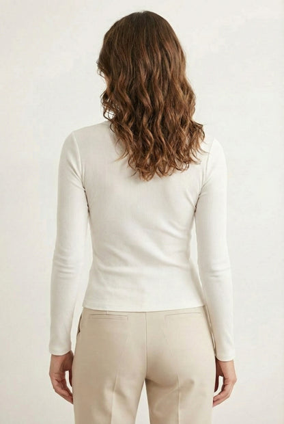 Woman wearing the LOHNR Haven Henley in Cloud White, a crisp white ribbed long-sleeve top with a button placket, styled for effortless everyday luxury.