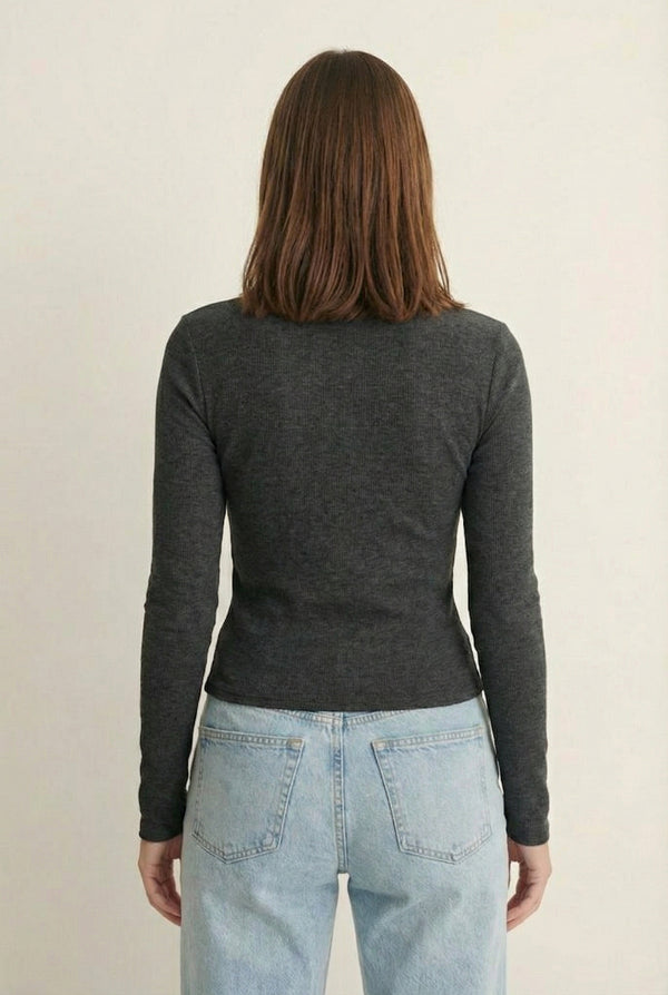 Woman wearing the LOHNR Haven Henley in Heather Charcoal, a dark grey ribbed long-sleeve top with a button placket, styled for effortless everyday luxury.