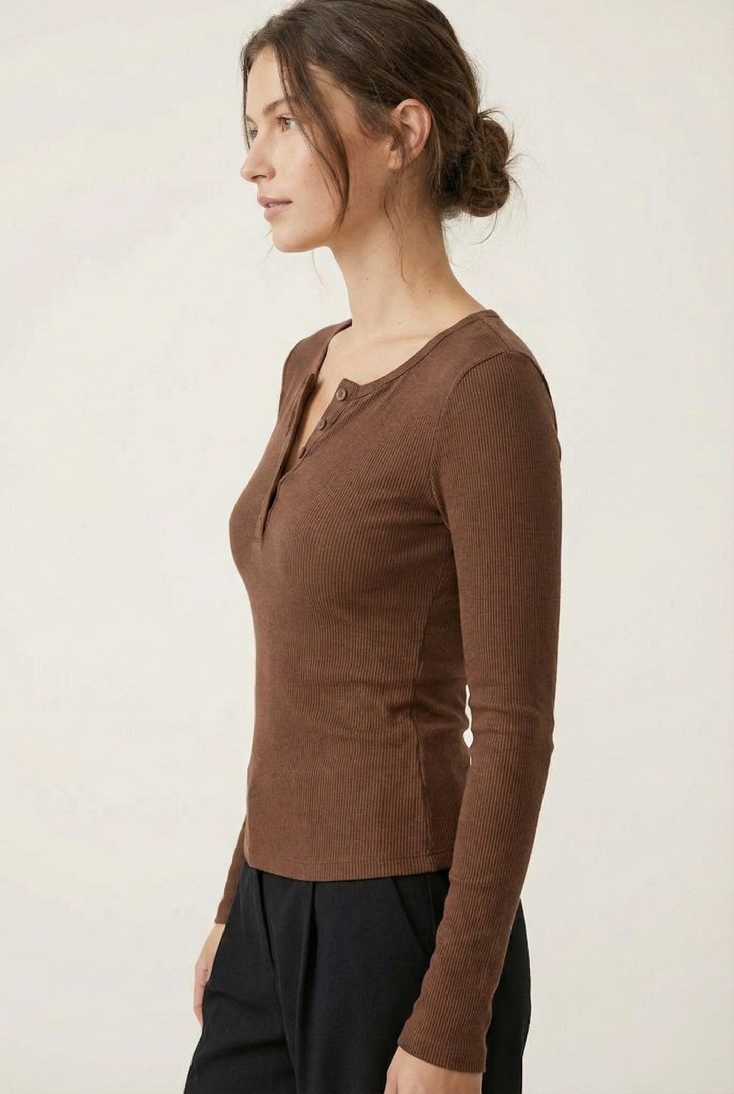 Woman wearing the LOHNR Haven Henley in Truffle, a rich brown ribbed long-sleeve top with a button placket, styled for effortless everyday luxury.