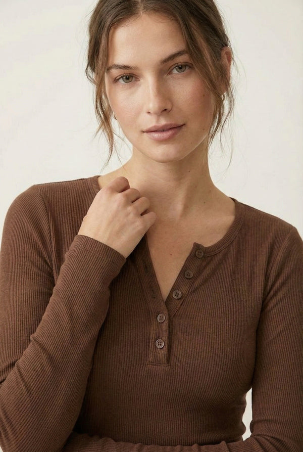 Woman wearing the LOHNR Haven Henley in Truffle, a rich brown ribbed long-sleeve top with a button placket, styled for effortless everyday luxury.