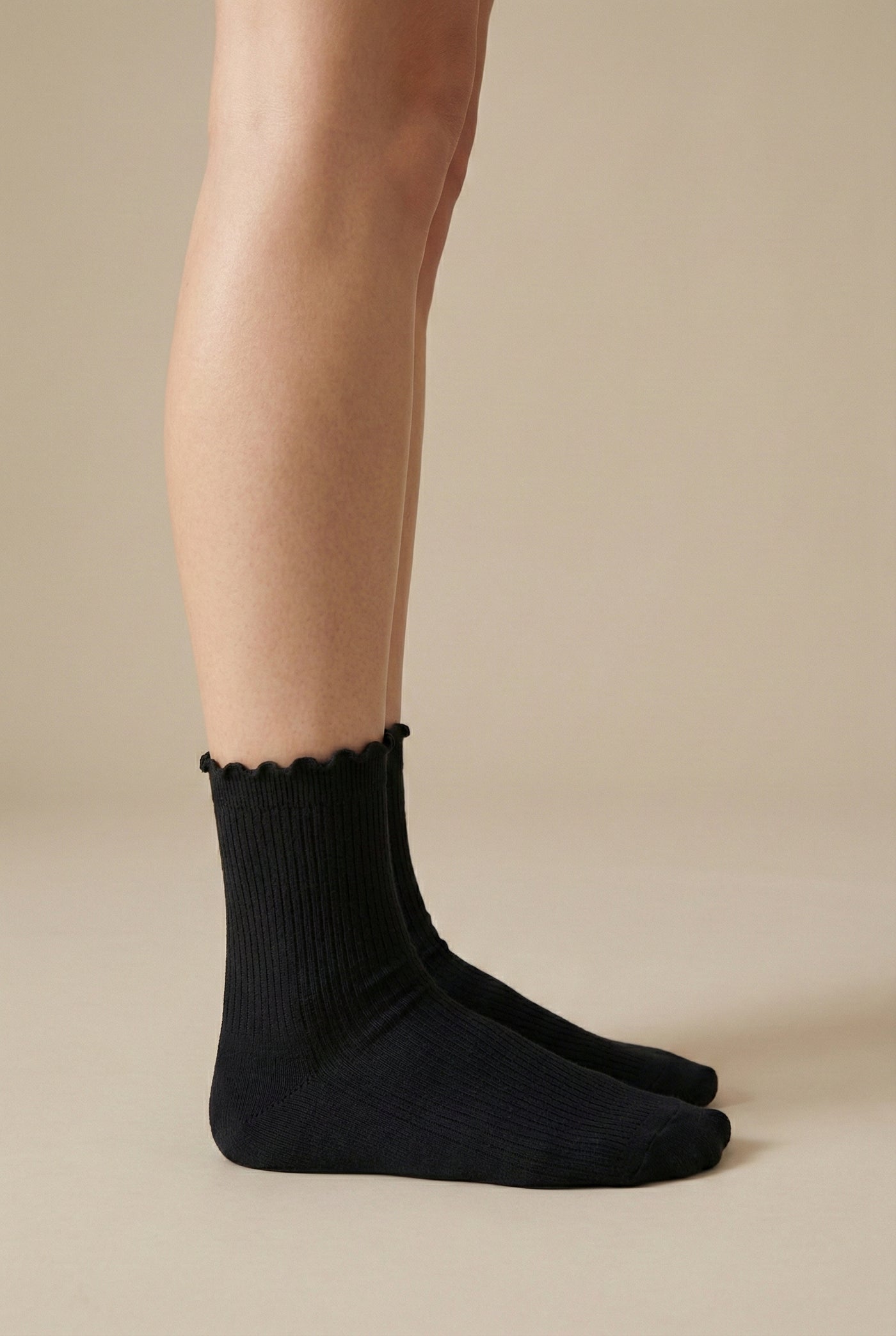 LOHNR Lacey Sock in Charcoal - A dark grey ruffle-edge crew sock that balances functional stretch with an elegant, textured ribbed design for elevated loungewear styling.