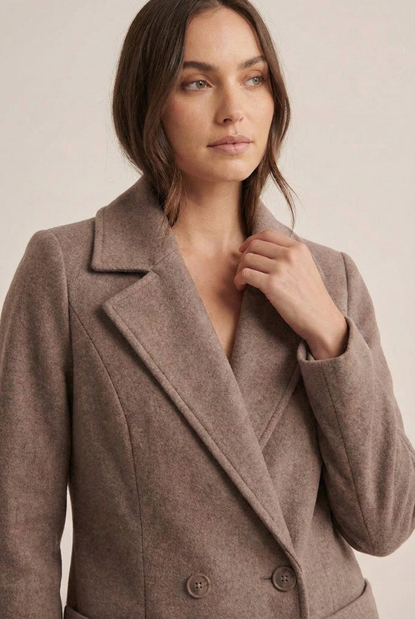 Fawn taupe Mercer Coat by LOHNR, a tailored faux wool trench coat featuring structured lapels, deep utility pockets, and a refined quiet luxury aesthetic.