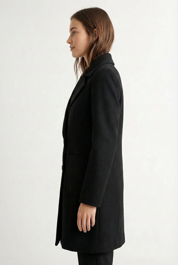 Onyx black Mercer Coat by LOHNR, a tailored faux wool trench coat featuring structured lapels, deep utility pockets, and a refined quiet luxury aesthetic.