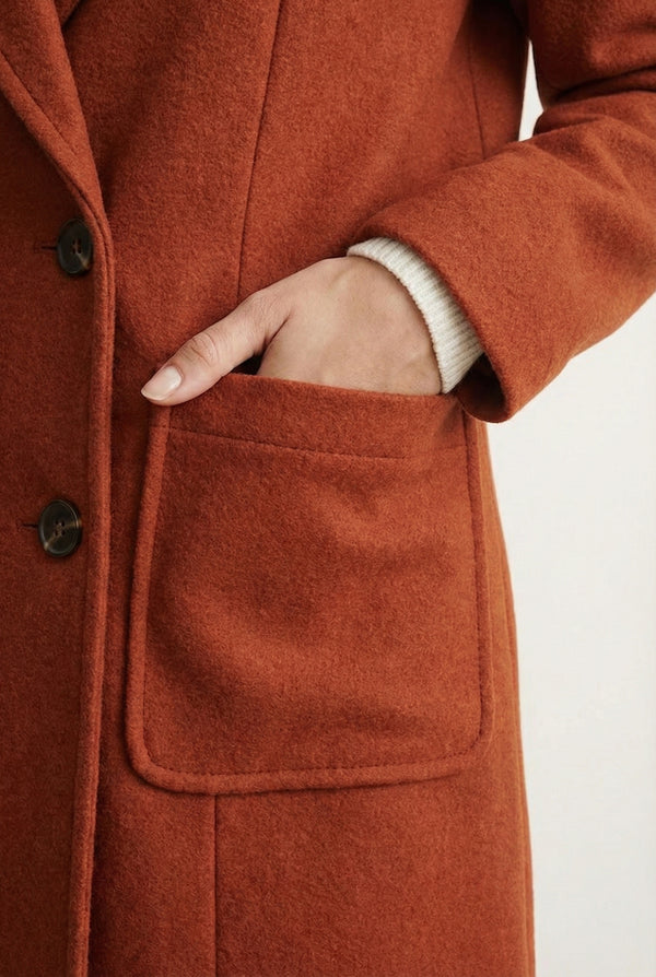 Sienna rust Mercer Coat by LOHNR, a tailored faux wool trench coat featuring structured lapels, deep utility pockets, and a refined quiet luxury aesthetic.