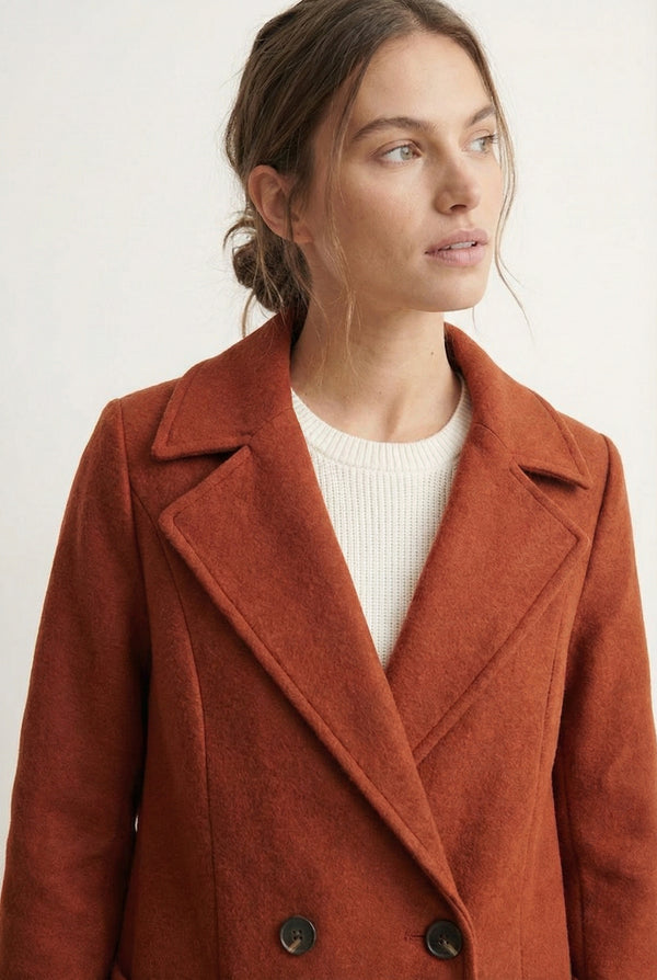 Sienna rust Mercer Coat by LOHNR, a tailored faux wool trench coat featuring structured lapels, deep utility pockets, and a refined quiet luxury aesthetic.