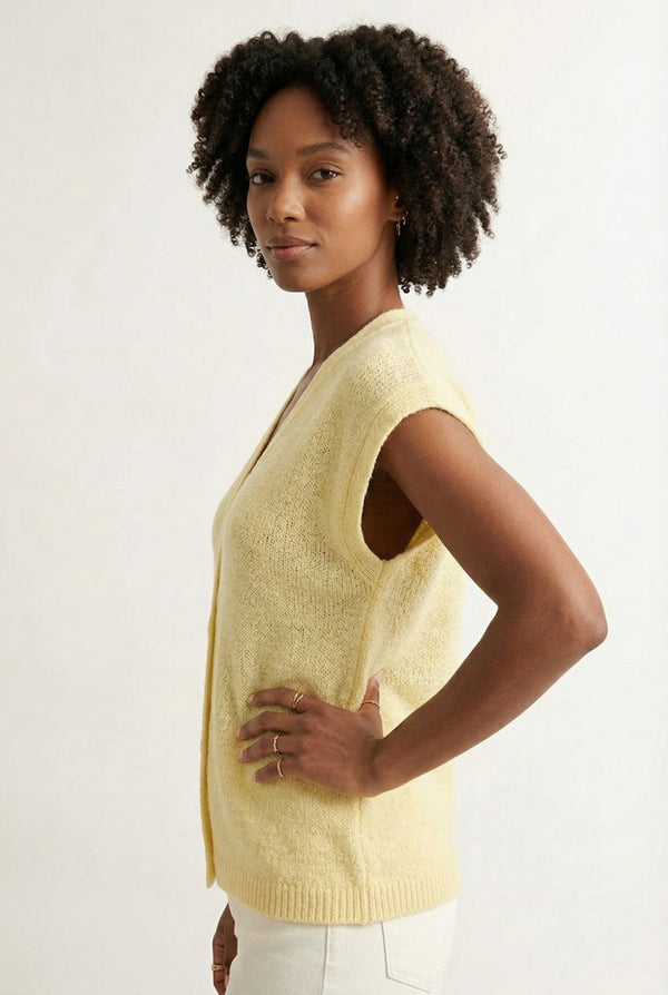 Woman modeling the LOHNR short sleeve v-neck knit top in pale yellow Meringue featuring a button-down front.