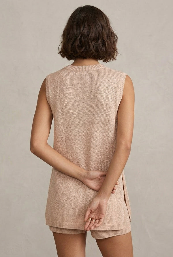 A woman wearing the LOHNR Slouch Tunic Set in Glossy Sand, a neutral beige sleeveless knit loungewear set.