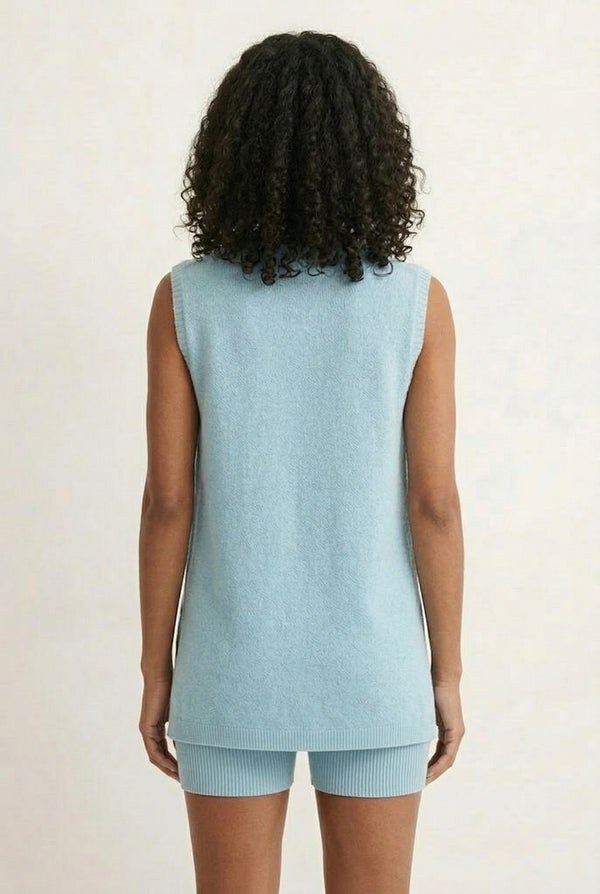 A woman wearing the LOHNR Slouch Tunic Set in Iced Sky, a soft pale blue sleeveless tunic and shorts set.