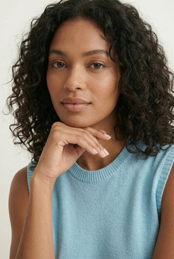 A woman wearing the LOHNR Slouch Tunic Set in Iced Sky, a soft pale blue sleeveless tunic and shorts set.