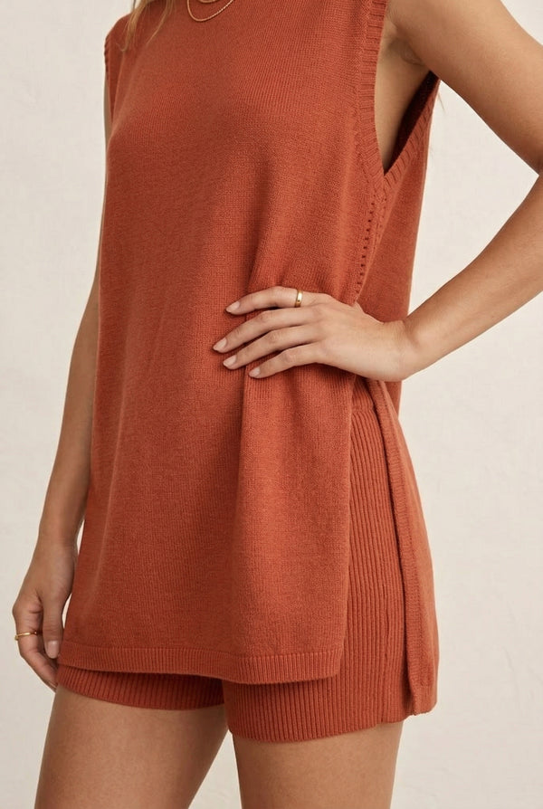A woman wearing the LOHNR Slouch Tunic Set in Spiced Clay, an earthy terracotta-toned sleeveless knit lounge set.
