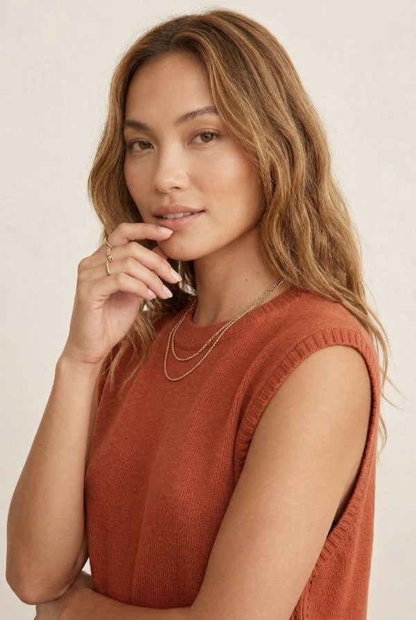 A woman wearing the LOHNR Slouch Tunic Set in Spiced Clay, an earthy terracotta-toned sleeveless knit lounge set.