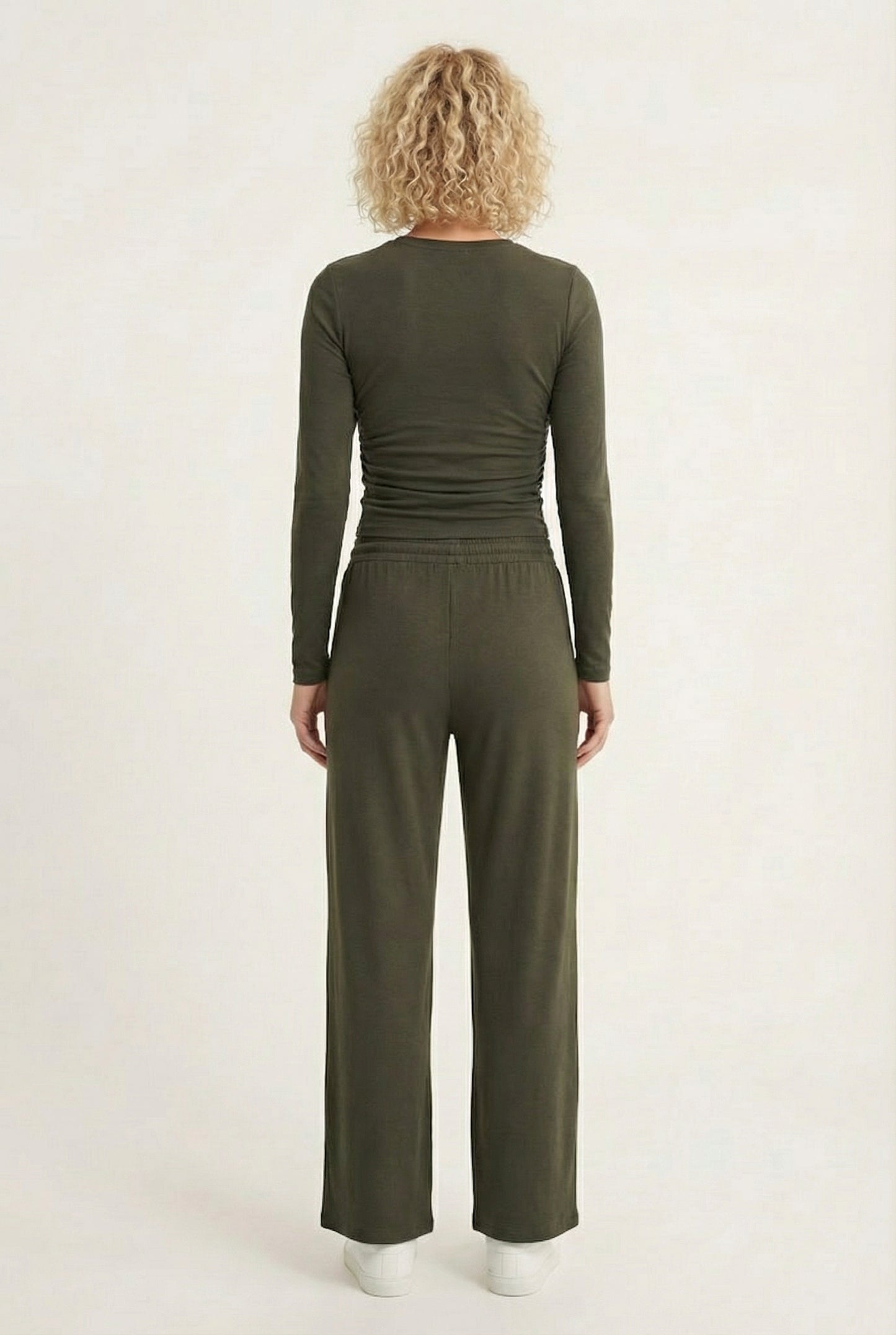 Model wearing The Rive Set sleek stretch lounge set in Cypress by Lohnr, featuring a ruched long-sleeve top and wide-leg drawstring pants