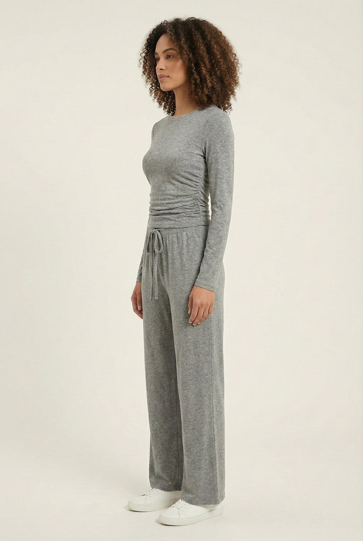Model wearing The Rive Set sleek stretch lounge set in Graphite by Lohnr, featuring a ruched long-sleeve top and wide-leg drawstring pants