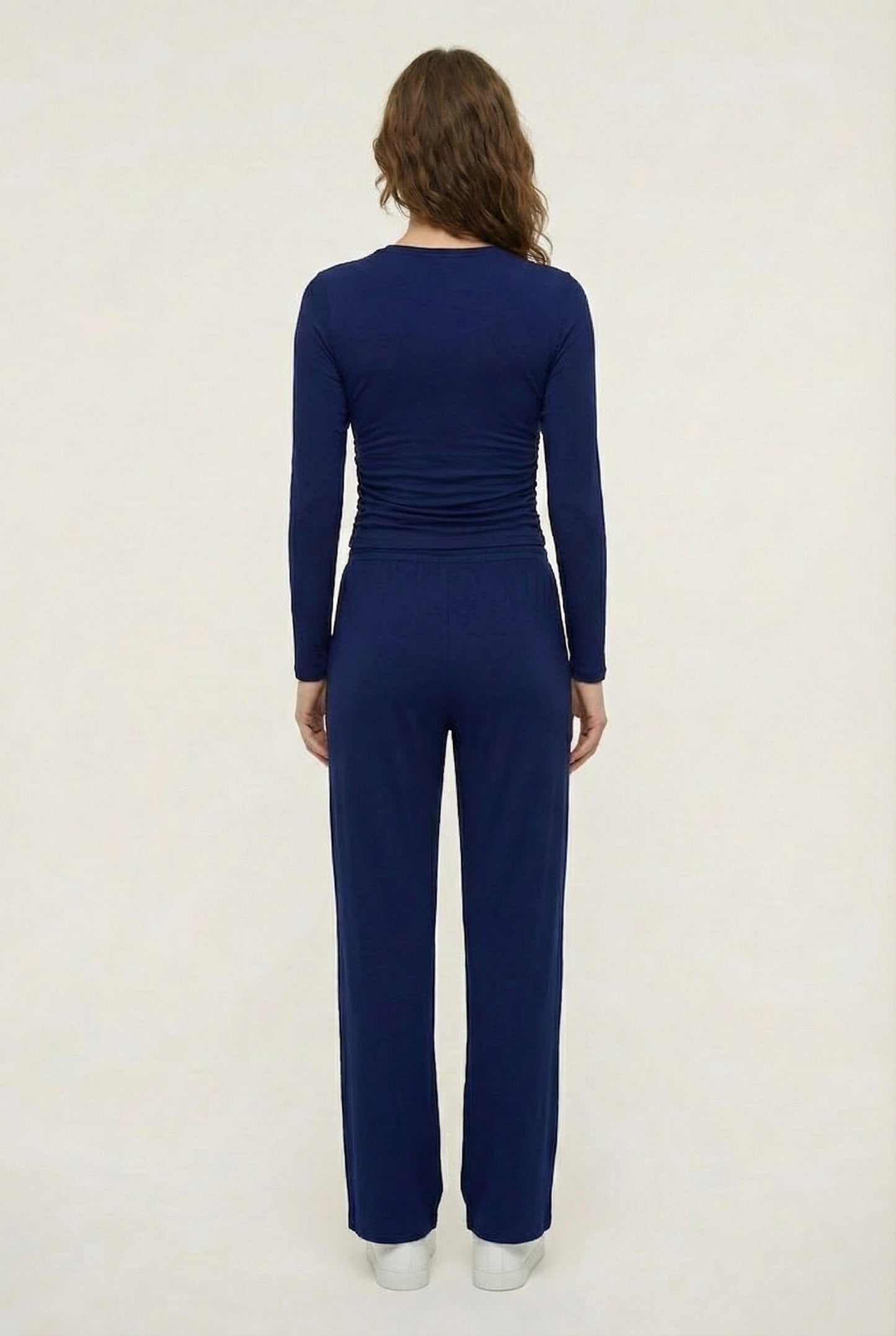 Model wearing The Rive Set sleek stretch lounge set in Indigo by Lohnr, featuring a ruched long-sleeve top and wide-leg drawstring pants