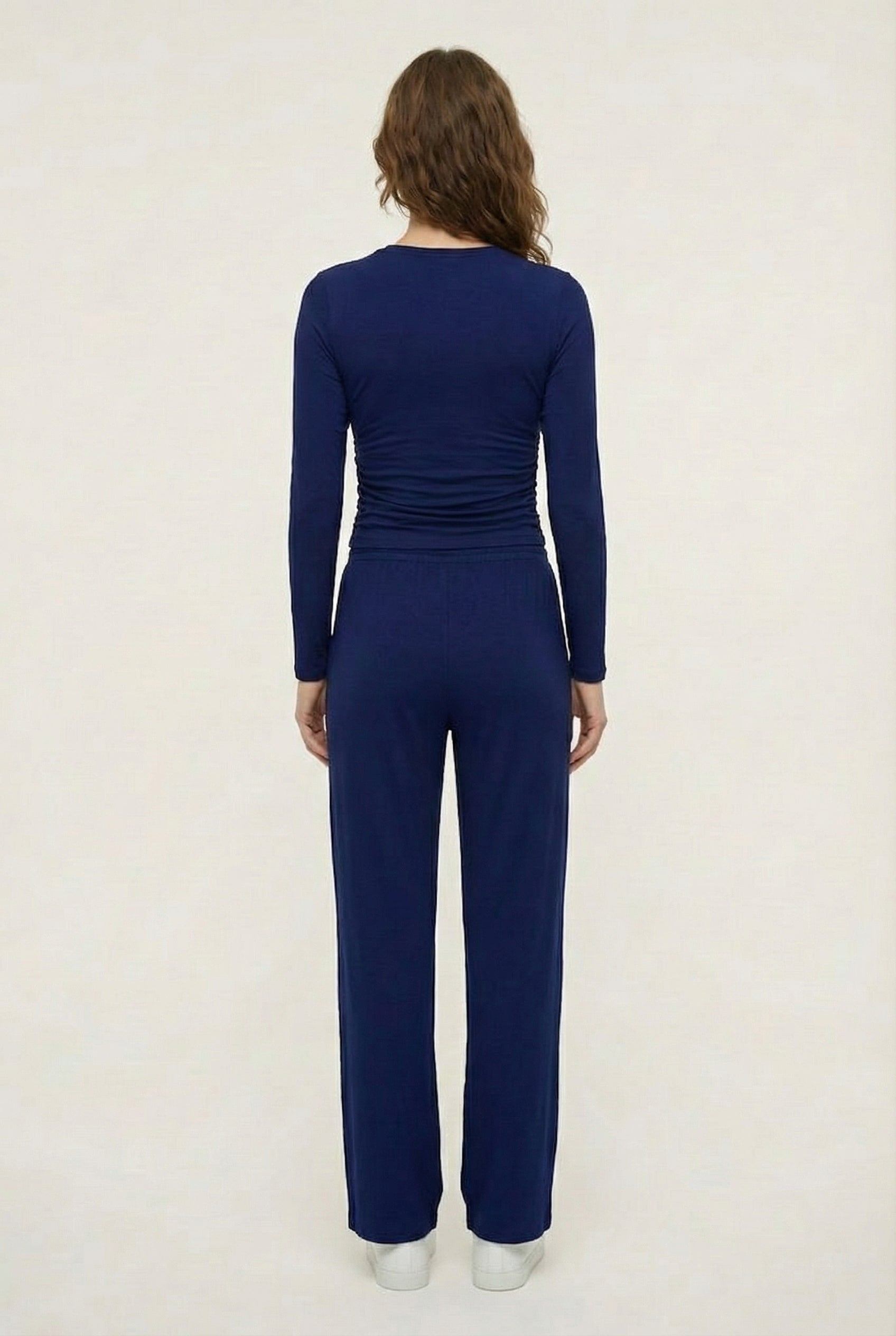 Model wearing The Rive Set sleek stretch lounge set in Indigo by Lohnr, featuring a ruched long-sleeve top and wide-leg drawstring pants