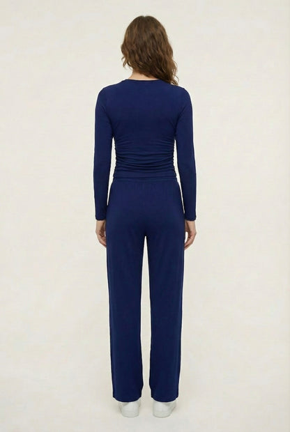 Model wearing The Rive Set sleek stretch lounge set in Indigo by Lohnr, featuring a ruched long-sleeve top and wide-leg drawstring pants