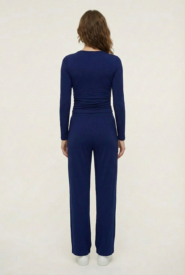 Model wearing The Rive Set sleek stretch lounge set in Indigo by Lohnr, featuring a ruched long-sleeve top and wide-leg drawstring pants
