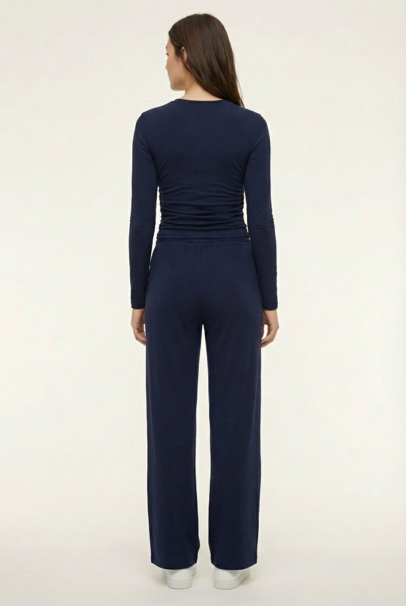 Model wearing The Rive Set sleek stretch lounge set in Midnight by Lohnr, featuring a ruched long-sleeve top and wide-leg drawstring pants