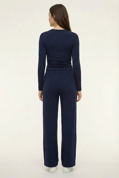 Model wearing The Rive Set sleek stretch lounge set in Midnight by Lohnr, featuring a ruched long-sleeve top and wide-leg drawstring pants