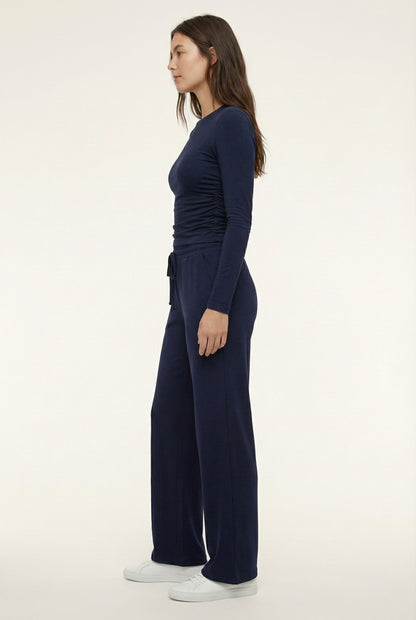 Model wearing The Rive Set sleek stretch lounge set in Midnight by Lohnr, featuring a ruched long-sleeve top and wide-leg drawstring pants