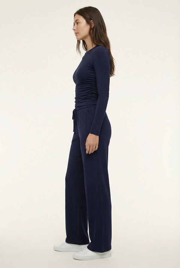 Model wearing The Rive Set sleek stretch lounge set in Midnight by Lohnr, featuring a ruched long-sleeve top and wide-leg drawstring pants