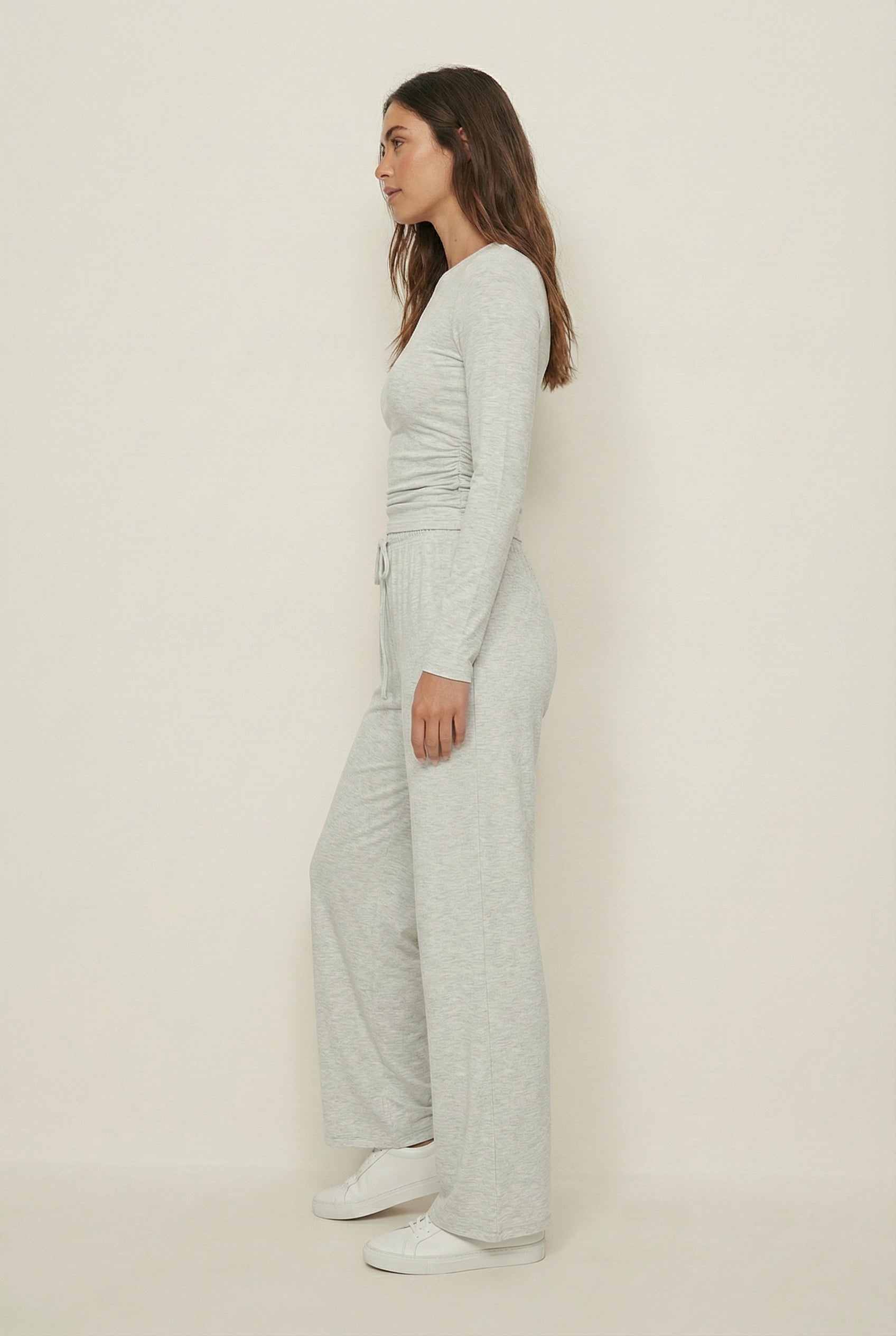 Model wearing The Rive Set sleek stretch lounge set in Mist by Lohnr, featuring a ruched long-sleeve top and wide-leg drawstring pants