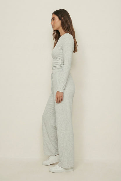 Model wearing The Rive Set sleek stretch lounge set in Mist by Lohnr, featuring a ruched long-sleeve top and wide-leg drawstring pants