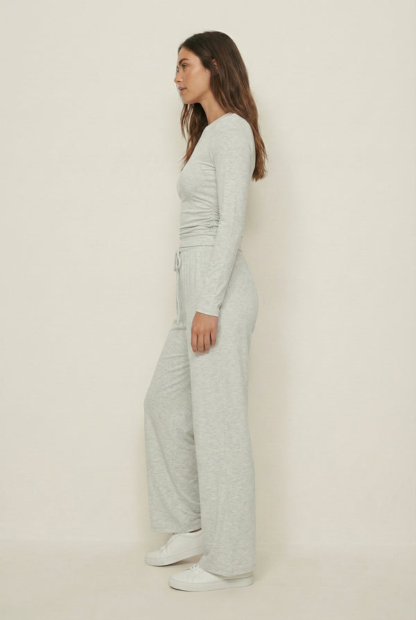 Model wearing The Rive Set sleek stretch lounge set in Mist by Lohnr, featuring a ruched long-sleeve top and wide-leg drawstring pants