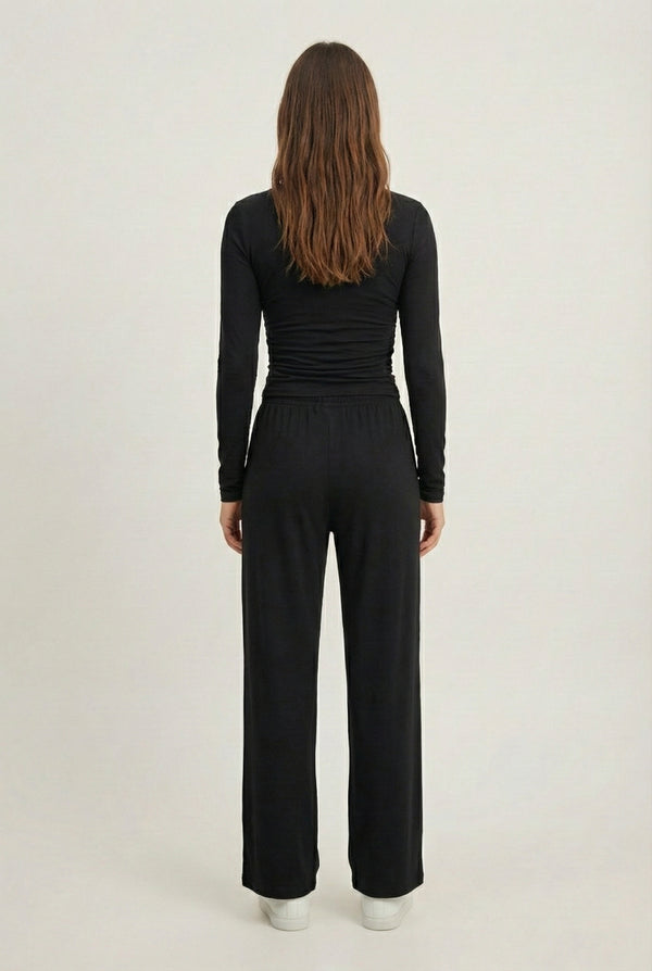 Model wearing The Rive Set sleek stretch lounge set in Noir by Lohnr, featuring a ruched long-sleeve top and wide-leg drawstring pants