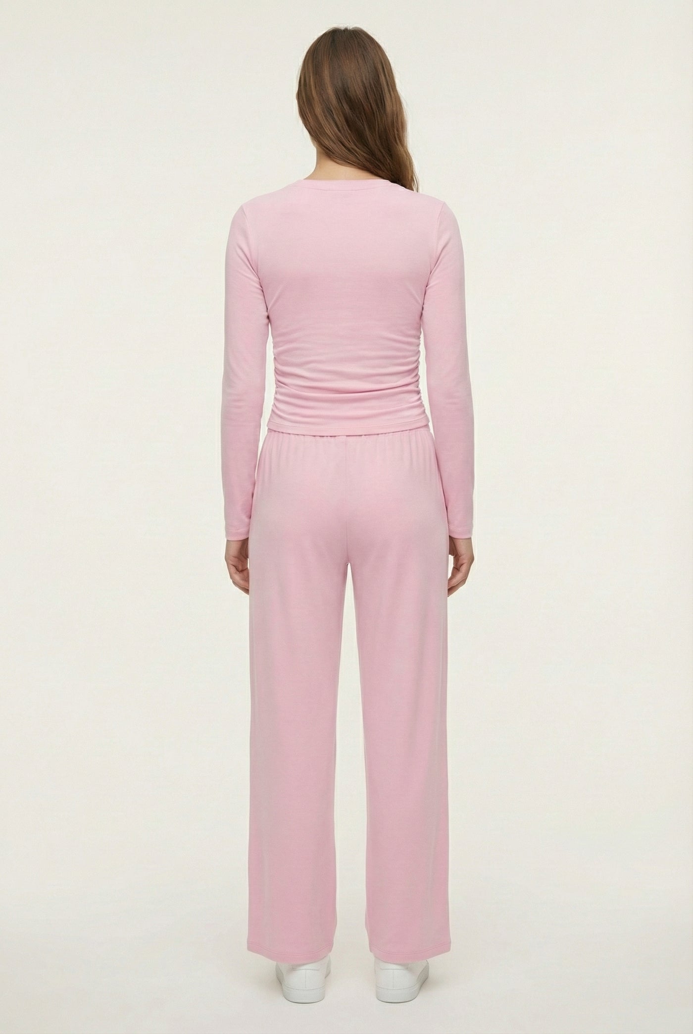 Model wearing The Rive Set sleek stretch lounge set in Rosewater by Lohnr, featuring a ruched long-sleeve top and wide-leg drawstring pants