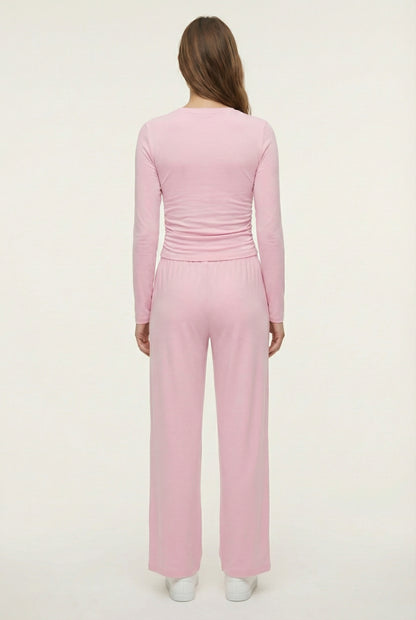 Model wearing The Rive Set sleek stretch lounge set in Rosewater by Lohnr, featuring a ruched long-sleeve top and wide-leg drawstring pants