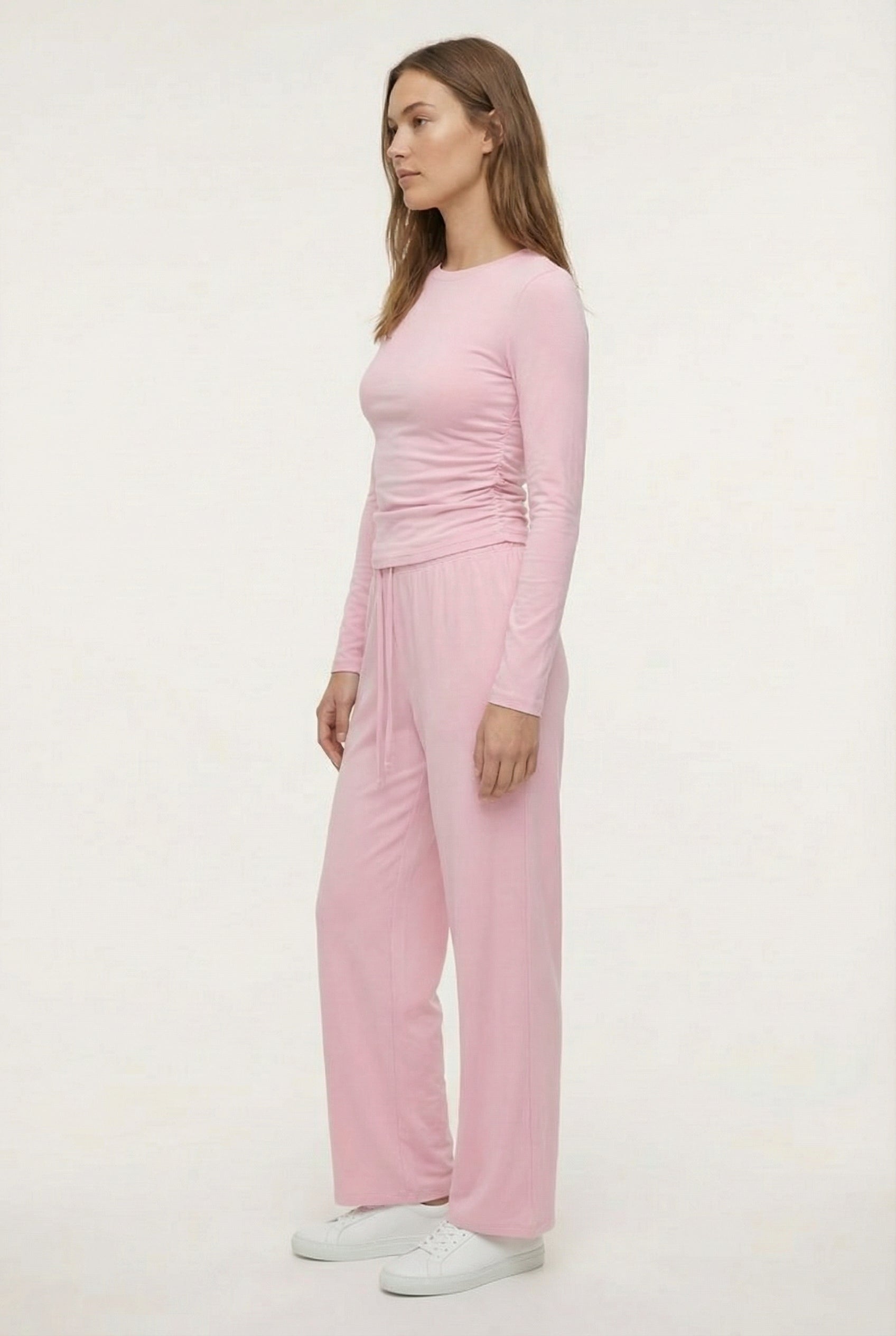 Model wearing The Rive Set sleek stretch lounge set in Rosewater by Lohnr, featuring a ruched long-sleeve top and wide-leg drawstring pants