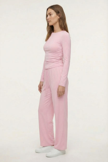 Model wearing The Rive Set sleek stretch lounge set in Rosewater by Lohnr, featuring a ruched long-sleeve top and wide-leg drawstring pants