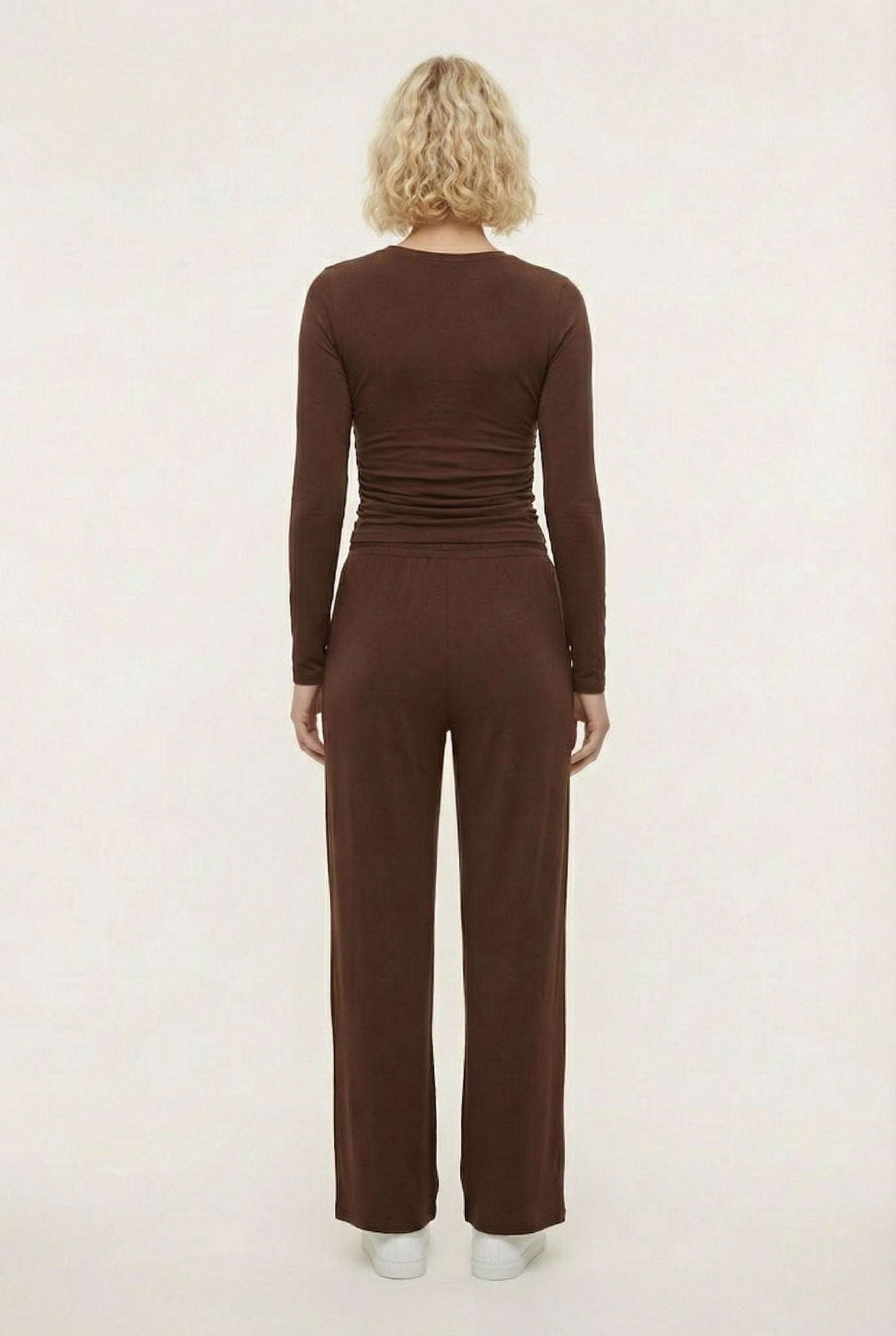 Model wearing The Rive Set sleek stretch lounge set in Truffle by Lohnr, featuring a ruched long-sleeve top and wide-leg drawstring pants