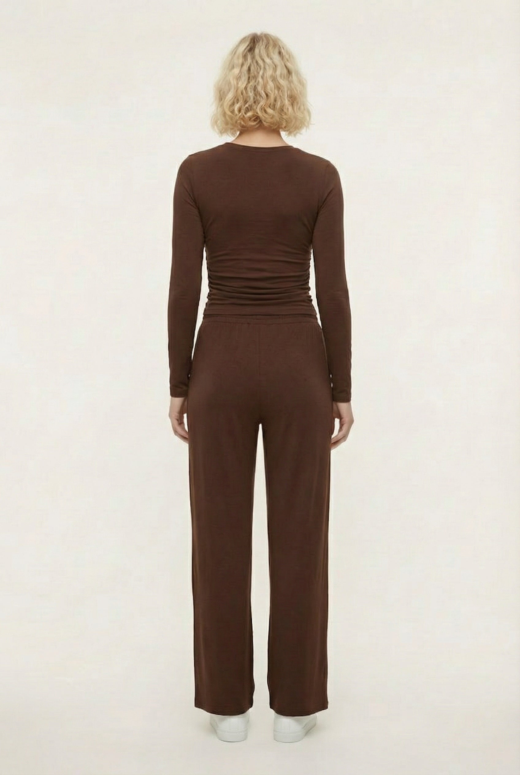 Model wearing The Rive Set sleek stretch lounge set in Truffle by Lohnr, featuring a ruched long-sleeve top and wide-leg drawstring pants