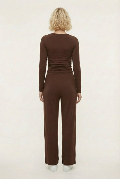 Model wearing The Rive Set sleek stretch lounge set in Truffle by Lohnr, featuring a ruched long-sleeve top and wide-leg drawstring pants