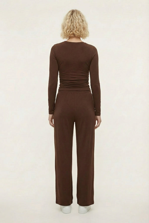 Model wearing The Rive Set sleek stretch lounge set in Truffle by Lohnr, featuring a ruched long-sleeve top and wide-leg drawstring pants