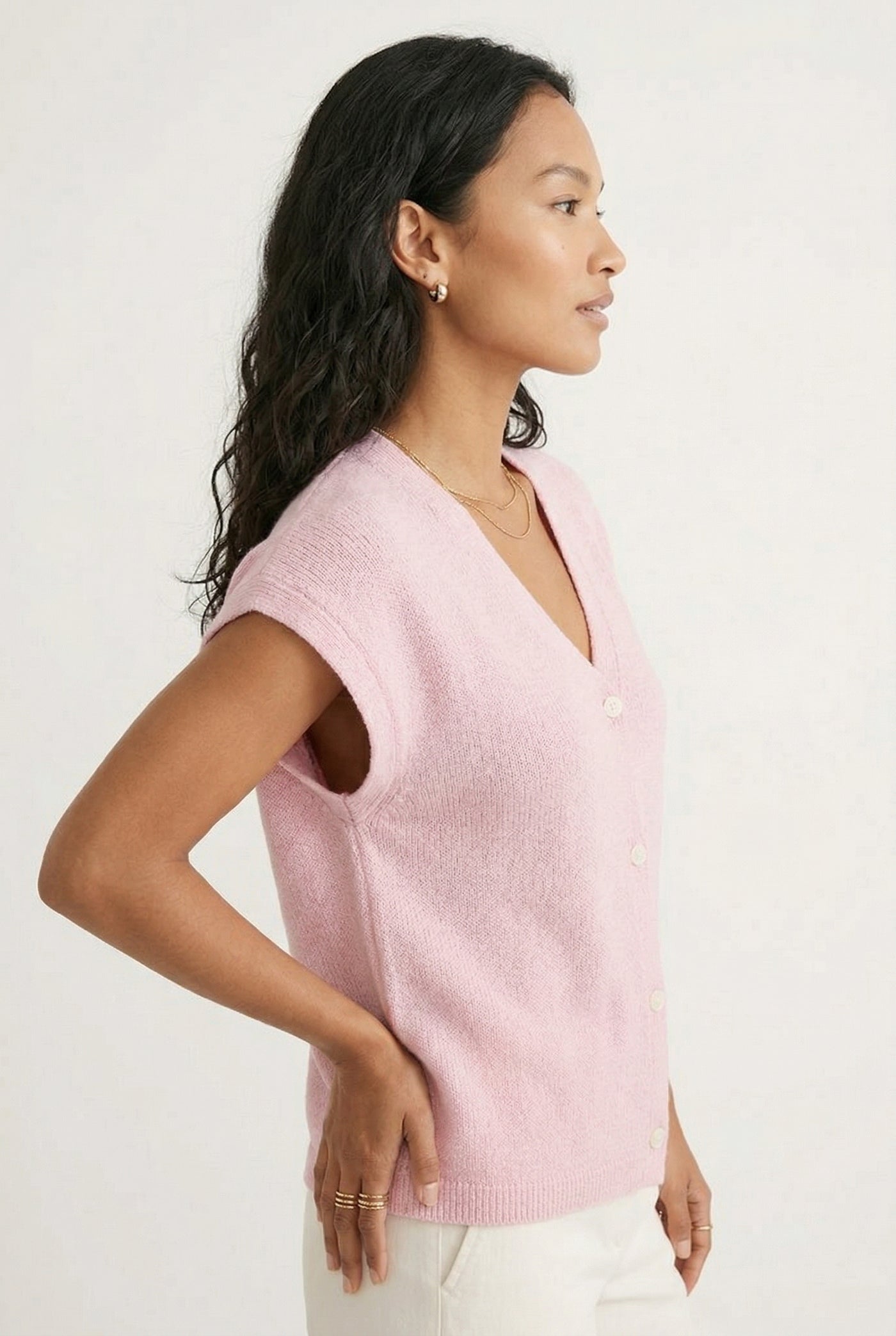 Woman modeling the LOHNR short sleeve v-neck knit top in light pink Ashen Rose featuring a button-down front.