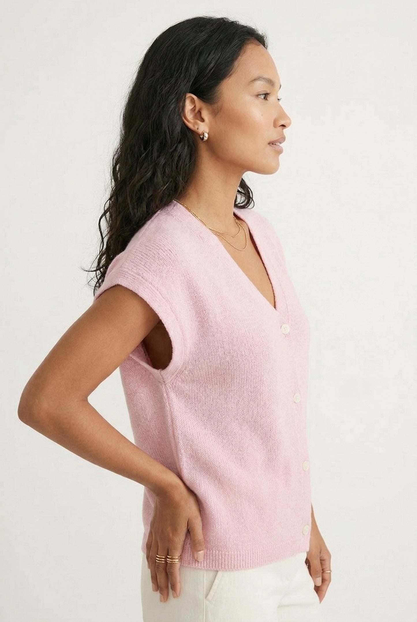 Woman modeling the LOHNR short sleeve v-neck knit top in light pink Ashen Rose featuring a button-down front.